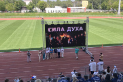 Участники наблюдают за трансляцией на стадионе